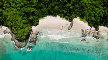 Kristal berrak turkuaz sular plajla buluşuyor. Dalgalar yavaşça kıyıya çarpıyor. El Nido, Palawan. Filipinler.