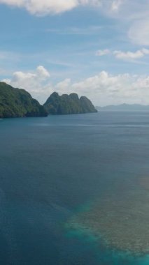 Tapiutan Adası ile Matinloc Adası arasındaki mavi deniz ve mercanlar. El Nido, Palawan. Filipinler. Dikey görünüm.