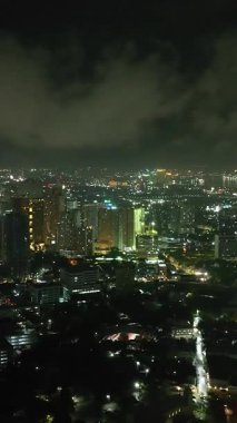 Modern binalarla çarpıcı şehir Cebu 'nun kuşları. Gece manzarası. Filipinler. Dikey video. Dikey.