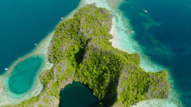 Kara Göl 'ün gökyüzü manzarası yüksek tepelerle çevrilidir. Banul Sahili 'nin berrak sularında kayıklara atlamak. Coron, Palawan, Filipinler. 5 bin..