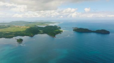 Kıyılardaki okyanus dalgalarının insansız hava aracı görüntüsü. Mavi denizle çevrili Kalampisauan Adası. Busuanga, Palawan, Filipinler.