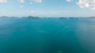 Huzurlu bir kanal yemyeşil adaları ayırır. Adaların çevresinde mercanlar olan tropik mavi deniz manzarası. El Nido, Filipinler.
