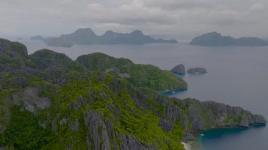 Miniloc Adası 'ndaki beyaz kumlu plajlar ve muhteşem kireçtaşı kayaları. El Nido, Palawan. Filipinler.