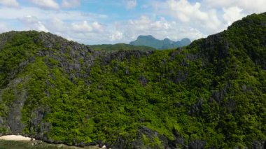 Matinloc Adası 'nda beyaz kumlu plaj ve kireç taşı oluşumu. El Nido, Palawan. Filipinler.