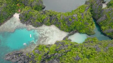 Miniloc Adası 'ndaki muhteşem kireçtaşı kayalarıyla çevrili tekneli lagünlerin havadan görüntüsü. El Nido, Filipinler. Palawan.