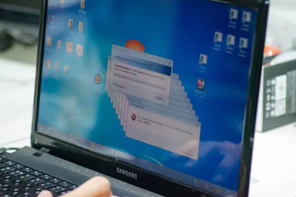 Bilgisayarı kredi kartıyla tutan bir elin yakın çekimi.