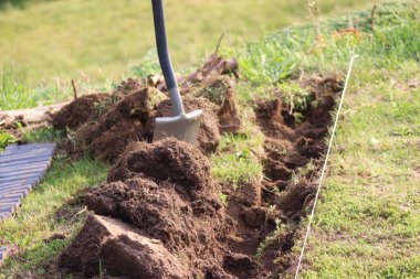 Bahçe işleri, bahçe kenarlarının kurulumu. Kürekle kazılmış basit bir siper.