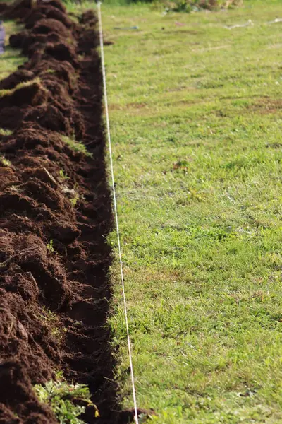 stock image Garden work, installation of garden edging. A simple trench dug with a spade.