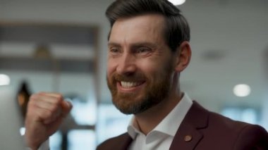 Neşeli adam yakın planda el kaldırıyor. Akıllı profesyonel evet hareketi yapıyor. Ofis müdürü iyi bir e-posta aldığı için sevinirken kendini mutlu hissediyor. Şirket yaşam tarzı kavramı