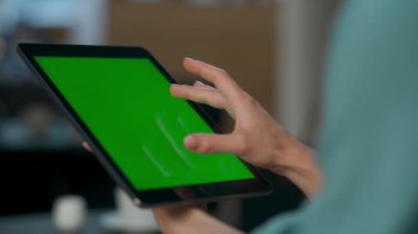 Kadın yeşil ekran cihazını yakınlaştırıyor. Mockup dijital bilgisayarda yeni uygulamayı deneyen başarılı geliştirici. Bilinmeyen proje yöneticisi lüks açık alanda krom tuş tabletine dokunuyor