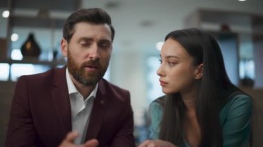 Başarılı girişimci çift ofiste müşterilerini internetten konuşuyor. İş adamları iş yerinde internet sohbet konferansında pazarlama satışlarını tartışıyor. Laptop video çağrısında açıklayan adam 