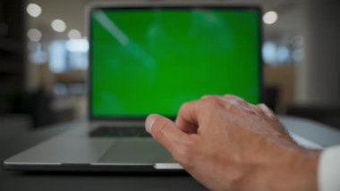 Salondaki yeşil ekran cihazında dokunmatik ped kullanan tanınmayan bir adam. Kapalı alanda krom tuşlu bilgisayara dokunan yakın çekim denetleyicisi elleri. Bilinmeyen CEO çevrimiçi çalışıyor. Modern dijital proje çalışma kavramı 