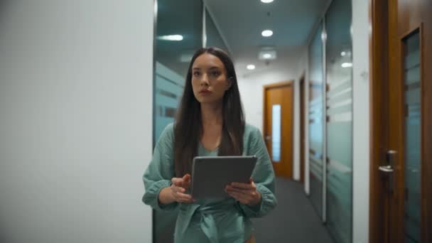 女性最高経営責任者 Ceo がオフィスでタブレットPcを検索 現代の職場の廊下を歩く忙しいマネージャー ガラスの壁の廊下で企業データを探しているビジネスマン プロの多様なコンセプト — ストック動画