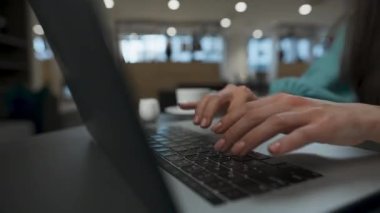 Ofisteki tanınmayan CEO 'nun internet laptopuna yakından bakması. Kadın elleri klavyede yavaş çekimde daktilo kullanıyor. Açık alan ortak çalışmasında bilgisayar üzerinde çalışma yapan başarılı proje yöneticisi 