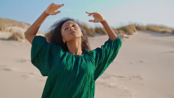 黒のドレスで砂の砂漠で踊る魅力的な女の子のインスピレーションを閉じる 砂丘で官能的なダンスの感情を表現するカーリーブルネットのパフォーマー アフリカ系アメリカ人の美しい女性ダンサーがスムーズに動く — ストック動画