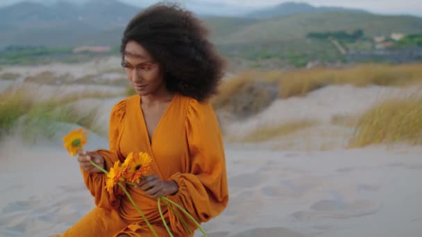 Portret Zrelaksowanej Afrykańskiej Modelki Zmierzchu Piaszczystej Pustyni Wąchającej Pomarańczowy Kwiat — Wideo stockowe