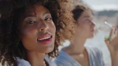Kapalı çekim gülümseyen kız yaz kokteyli içiyor. Mutlu Afro-Amerikan tatilleri kıyıdaki Igbt partneriyle romantik bir randevu geçiriyor. Çekici bir kadın poz veriyor. Güneş ışığında rahatlıyor. Tatil köyü reklamı