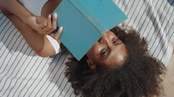 Ένα Κορίτσι Από Την Παραλία Διαβάζει Βιβλίο Ξαπλωμένο Μια Κουβέρτα — Αρχείο Βίντεο