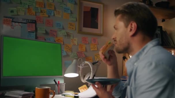 Guapo Freelancer Comiendo Sándwich Cuarto Oscuro Cerca Emocional Hombre Hablando — Vídeo de stock