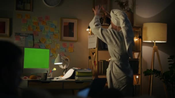 興奮した女性は クロマキーコンピュータを閉鎖ジェスチャー 主婦は モックアップPcのリアビューで美しい話を話しています シャワー後の夜に緑の画面装置を話すバスローブの女性 — ストック動画