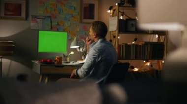Tanımlanamayan kişi, Mockup PC 'yi arıyor. Arka plandaki adam sanal toplantıda konuşuyor. Geceleri yeşil ekran bilgisayarındaki meslektaşlarını uzaktan açıklayan serbest çalışan bir adam.