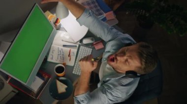 Ev işyeri manzarasında dans eden olumlu bir adam. Heyecanlı adam müzik dinliyor. Chroma Key PC 'de oynaşıyor. Yakın plan. Komik serbest çalışan geceleri tek başına eğleniyor.