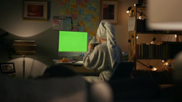 認識できない主婦がPcのクローズアップを話してる バックビュー女性のコーヒーをリモートで作業を飲む 緑の画面のコンピュータのビデオ通話を有するバスローブのゴシップ少女 夜におしゃべりする女 — ストック動画