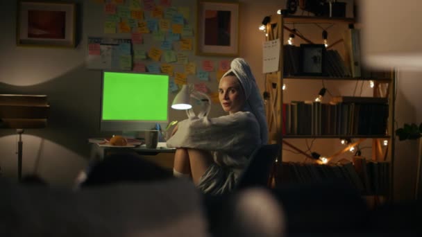 暗い部屋の密室で夫と話す驚くべき女性 クロマキーのデスクトップコンピュータで働く中で未知の配偶者をオンに疑問の女の子 自宅の職場で緑の画面のPcを使用してバスローブのフリーランス — ストック動画