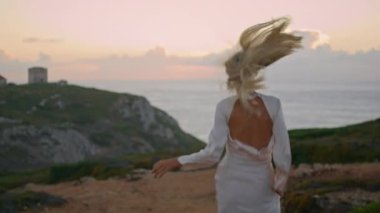 Sarışın kadın deniz kenarındaki şatoyu geziyor. Güzel boş vadiyi yöneten mutlu kız. Tasasız kadın elbise giyip doğayla baş başa eğleniyor. Çekici bir model, omzunun üstünden kameraya bakıyor