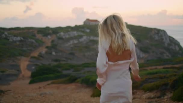 불명의 여자가 뒤쪽으로 이동하는 관광객 바다의 언덕을 탐험하는 광경을 즐기고 — 비디오