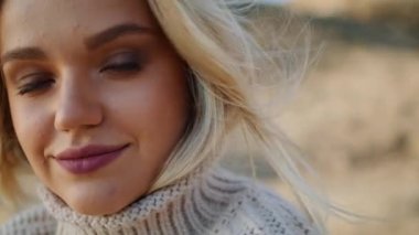 Sonbahar Vadisi portresinde gülümseyen sarışın kadın. Cazibeli kız kuru çim çölünde poz veriyor. Rüzgarlı saçlı kadın manzarayı rahatlatıyor. Rüya gibi model, güzel doğanın tadını çıkarıyor.