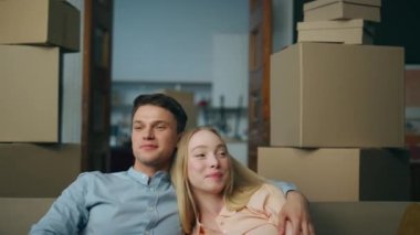 Mutlu yeni evliler yeni bir daireye taşınıp kendi evlerinin keyfini çıkarıyorlar. Karton kutunun yanındaki kanepede oturan genç evli çift etrafa bakınıyor. Tatmin olmuş aile kucaklaşması yeni dairede dinleniyor..