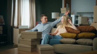 Kanepede oturan mutlu genç çift yeni bir eve taşınmak için heyecanlı. Sarışın kadını kucaklayan çekici bir adam. Etrafı karton kutularla çevrili rahat bir odada dinleniyor. Evli çift taşınmanın tadını çıkarıyor..