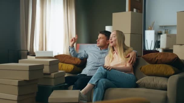 Jeune Couple Heureux Assis Sur Canapé Confortable Inspectant Salon Après — Video