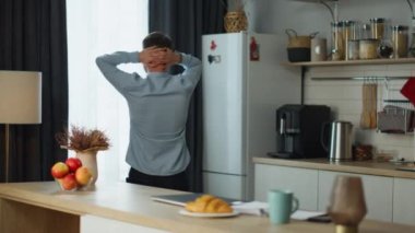 Stresli, serbest çalışan bir adam iş projesinden kalıyor. Mutfağa yürüyor ve depresyona giriyor. İş problemleri için endişelenen, şirketten kovulan genç adamın arka planda kalan görüntüsü. İş adamı krizi.