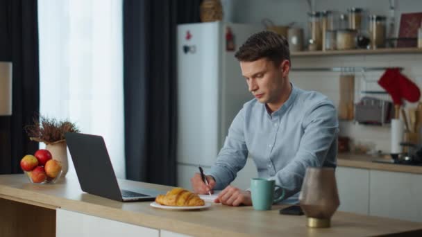 Εστιασμένος Άνθρωπος Κρατώντας Σημειώσεις Εργασίας Laptop Στην Άνετη Κουζίνα Και — Αρχείο Βίντεο