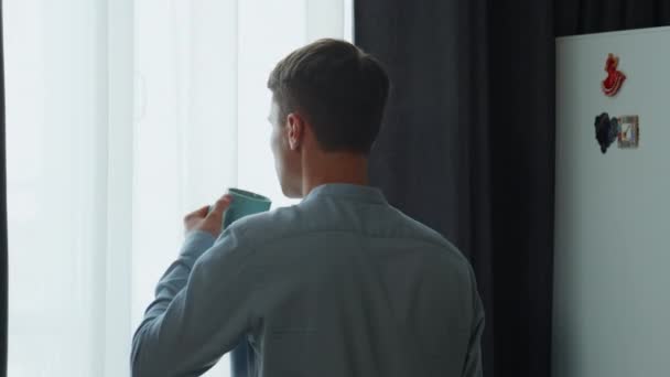 Baksidan Ung Man Dricker Kaffe Tittar Fönster Morgonen Okänd Självsäker — Stockvideo