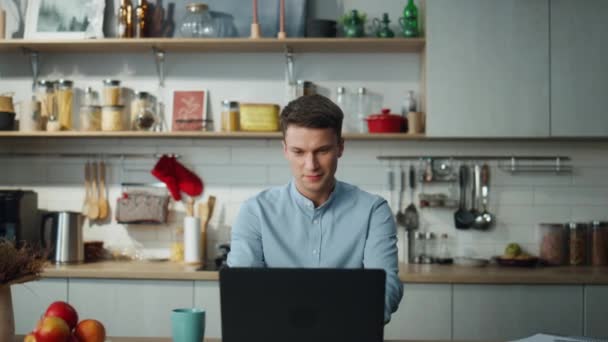 Szczęśliwy Atrakcyjny Mężczyzna Wyszukiwania Informacji Online Siedzi Kuchni Domowej Uśmiechnięty — Wideo stockowe
