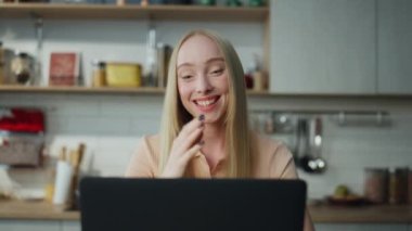Heyecanlı mutlu kadın web kamerasında gülüyor ve arkadaşlarıyla yakından konuşuyor. Çekici neşeli kız modern laptopta video kullanarak sanal toplantıdan zevk alıyor. Gülümseyen sarışın internette iletişim kuruyor..