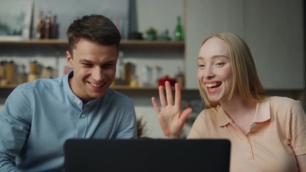 若い夫婦が自宅のキッチンの近くからのビデオ通話で話しています ライブ通信を楽しむWebカメラで仮想アプリでオンラインチャット幸せな距離の友人 素敵なペアの挨拶 — ストック動画