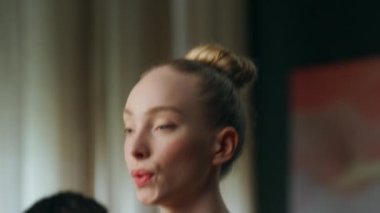 Çekici sarışın kız, erkek arkadaşıyla bacak kaslarını çalıştırıyor ve odada birlikte çömeliyor. Genç ve zinde bir çift aile antrenmanında nefes alma egzersizleri yapıyor. Karı koca sağlıklı vücut çalışıyor..