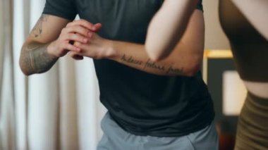 Formda adam evde zayıf bir kadınla çömelme antrenmanı yapıyor. Genç ve çekici bir çift güçlü bacaklar için egzersiz yapıyor. Aktif aile spor kıyafetleri içinde apartman dairesinde çalışıyor..
