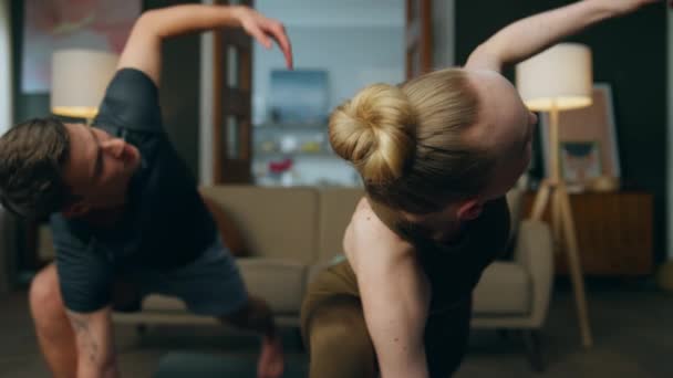 适合年轻的舞伴在漂亮的房间里练习瑜伽 穿着运动服的矮胖夫妇在家里摆着倒立的三角形 与男朋友一起锻炼瘦身的女人 — 图库视频影像