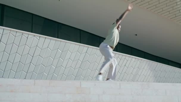 ストリートだけでコンテンポラリーダンスをするプラスチック製のパフォーマー ダークスキンの男は 都市のスタジアムの背景に個々のスタイルのダンスを準備する アフリカ系アメリカ人ダンサー 音楽の自由演奏をリハーサル — ストック動画