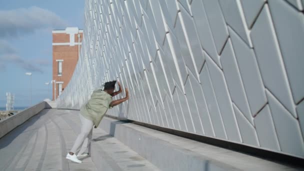 芸術人はスタジアムを一人で踊ってる 現代地区のコンクリート壁の外観カメラに触れる茶色の肌のダンサー アフリカ系アメリカ人の専門家は 都市で異なる現代的な技術を示す — ストック動画