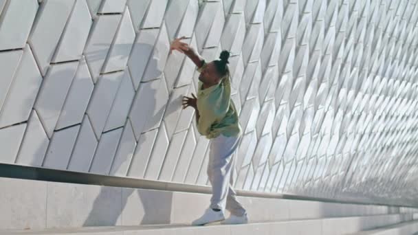 情熱的なパフォーマーだけで階段を踊る 都市部でコンテンポラリーダンスを練習している芸術家 抽象的な建物で個性を表現するアフリカ系アメリカ人男性 サブカルチャーの概念 — ストック動画