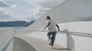 Şehirde tek başına dans eden adam. Esmer tenli sanatçı tek başına metal köprüde bacaklarını hareket ettiriyor. Sportif Afro-Amerikan dansçı açık havada dinamik dans icat ediyor. Alt kültür yaşam tarzı kavramı