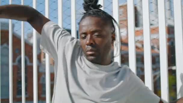 ドレッドロックスの男は都会の通りの近くで体を動かす アフリカ系アメリカ人男性の手の肖像ダンス 振付を行うダンサー スタイリッシュな芸術家は感情を表現する 現代のライフスタイルコンセプト — ストック動画
