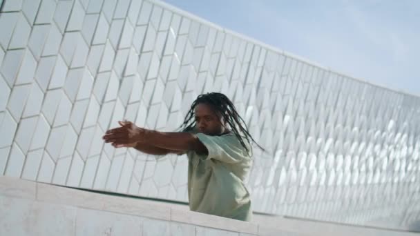 嘻哈男子跳舞街特写 时髦的舞者独自在露天排练 在抽象建筑附近练习新舞蹈的黑人头发表演者 准备上舞蹈课的非裔美国人 — 图库视频影像
