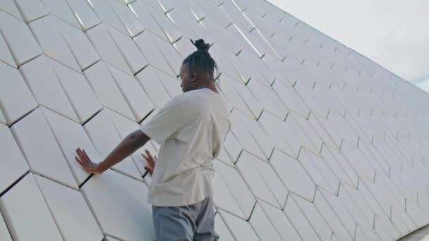 在城市建筑工地训练舞女 非裔美国人在混凝土墙边创造了新的自由式舞蹈 有灵感的表演者在街上排练 戏剧化的家伙看着城市的相机 — 图库视频影像